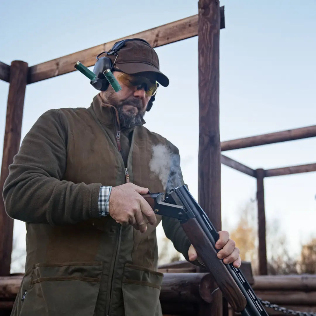 Smoking break-action shotgun displayed with Härkila Rannoch HSP Shooting Waistcoat