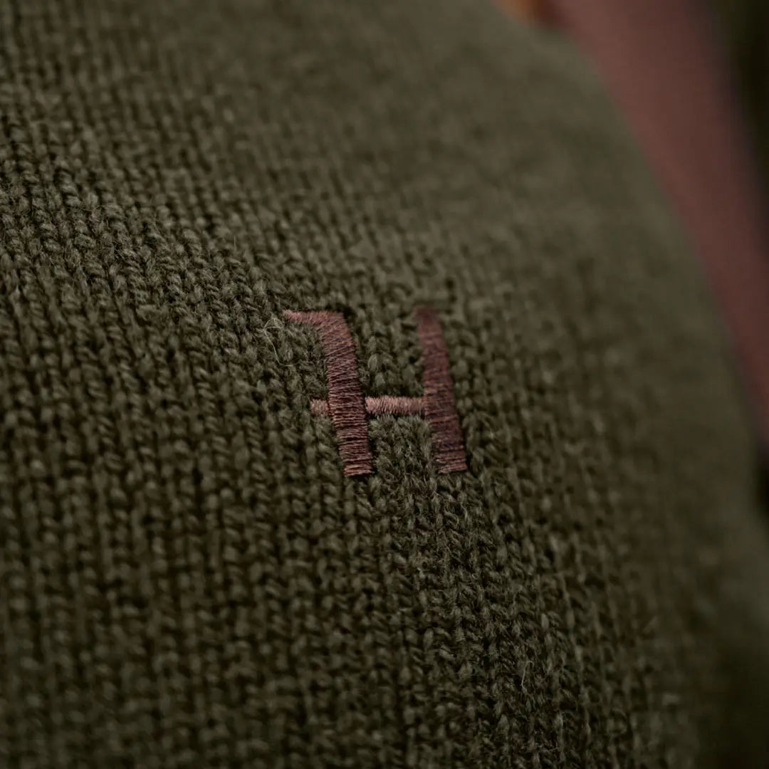 Green knitted fabric with embroidered letter on Härkila Vincent Merino Half Zip Pullover