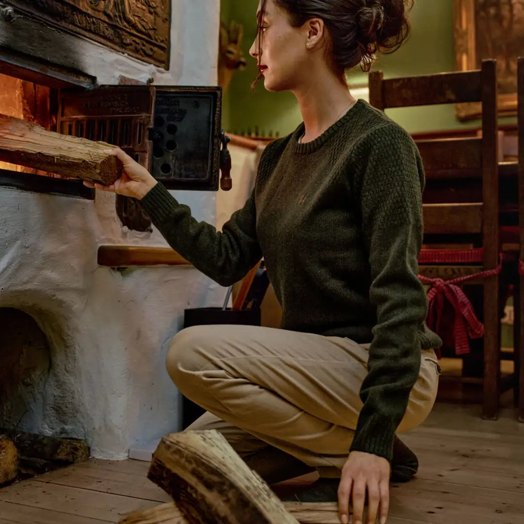 Woman loading firewood in Härkila Vinnie Womens Merino Pullover, comfy vinnie merino pullover