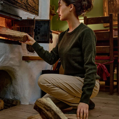 Woman loading firewood in Härkila Vinnie Womens Merino Pullover, comfy vinnie merino pullover