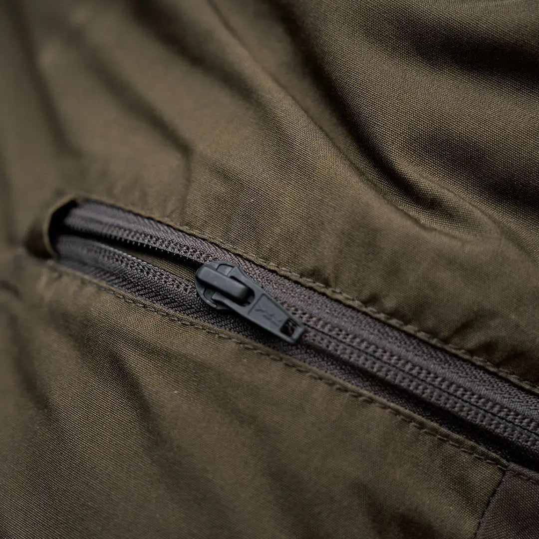 Olive green fabric Harkila Fjell Trousers with black zipper, perfect for country clothing
