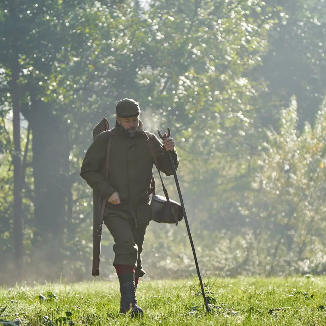 Hunter with rifle and walking stick wearing Harkila Kenmore GTX Breeks for outdoor adventure