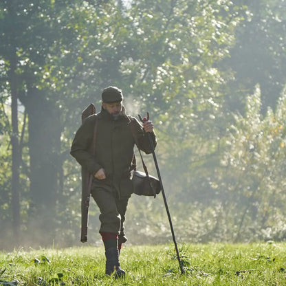 Hunter with rifle and walking stick wearing Harkila Kenmore GTX Breeks for outdoor adventure
