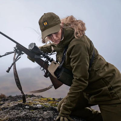 Soldier in military gear aiming sniper rifle, showcasing Harkila Pro Hunter GTX Ladies Jacket