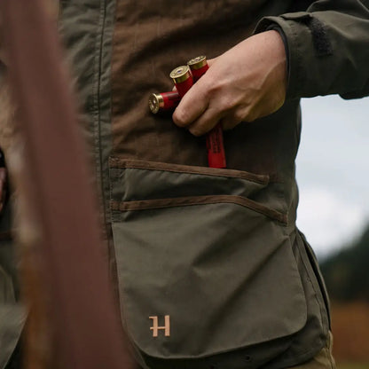 Harkila Rannoch HWS Shooting Jacket with pockets and monogrammed H, holding shotgun shells