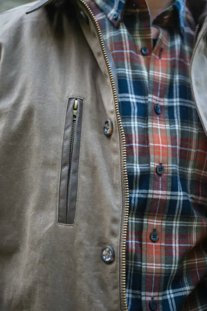 Brown leather jacket with zipper pocket and plaid shirt on Hoggs of Fife Balerno Waxed Canvas Barn Coat