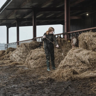 Person in Hay with Pitchfork Wearing Hoggs of Fife Green King II Waterproof Bib & Braces