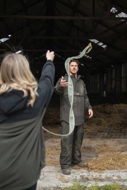 Green snake with patterned scales wrapped around arm, showcasing Hoggs of Fife Green King II waterproof smock, a popular green king fabric