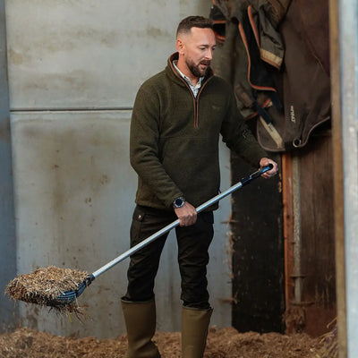 Jack Pyke half zip sherpa fleece pullover in green with black pants and rubber boots