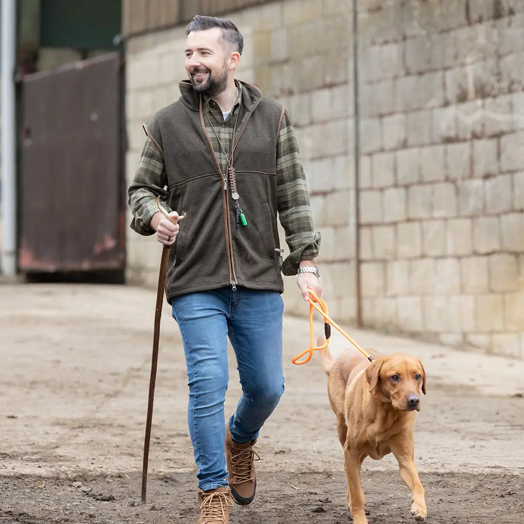 Man walking dog in Jack Pyke Melange Fleece Gilet Dark Olive outdoors