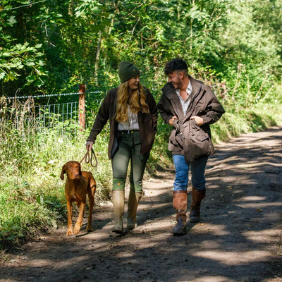 Two people walking a dog on a path wearing Jack Pyke Merino Wool Beanie in nature
