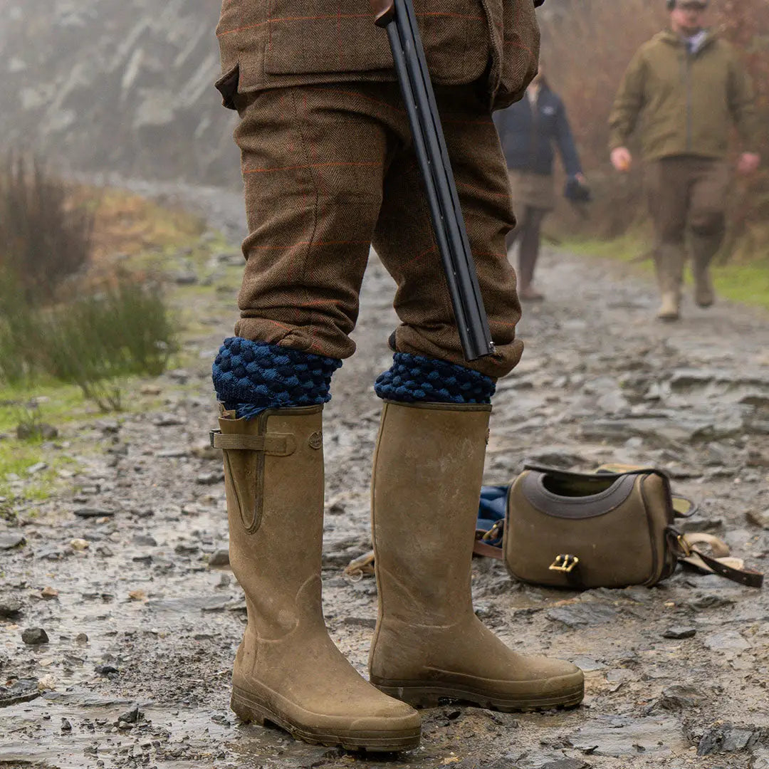 Tan rubber hunting boots with blue leg warmers in Jack Pyke country clothing