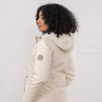 Woman wearing Lighthouse Isobel Coat in cream with a circular patch on the sleeve