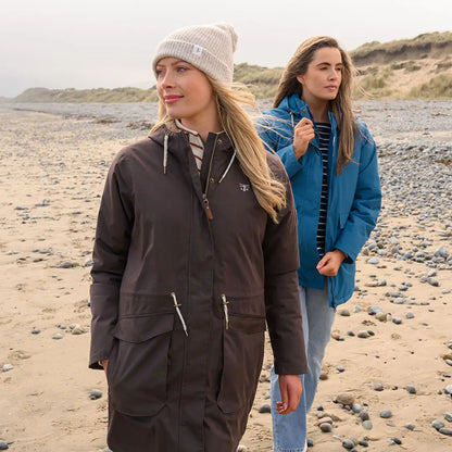 Two women in winter coats and beanies on a sandy beach wearing the Lighthouse Isobel Coat