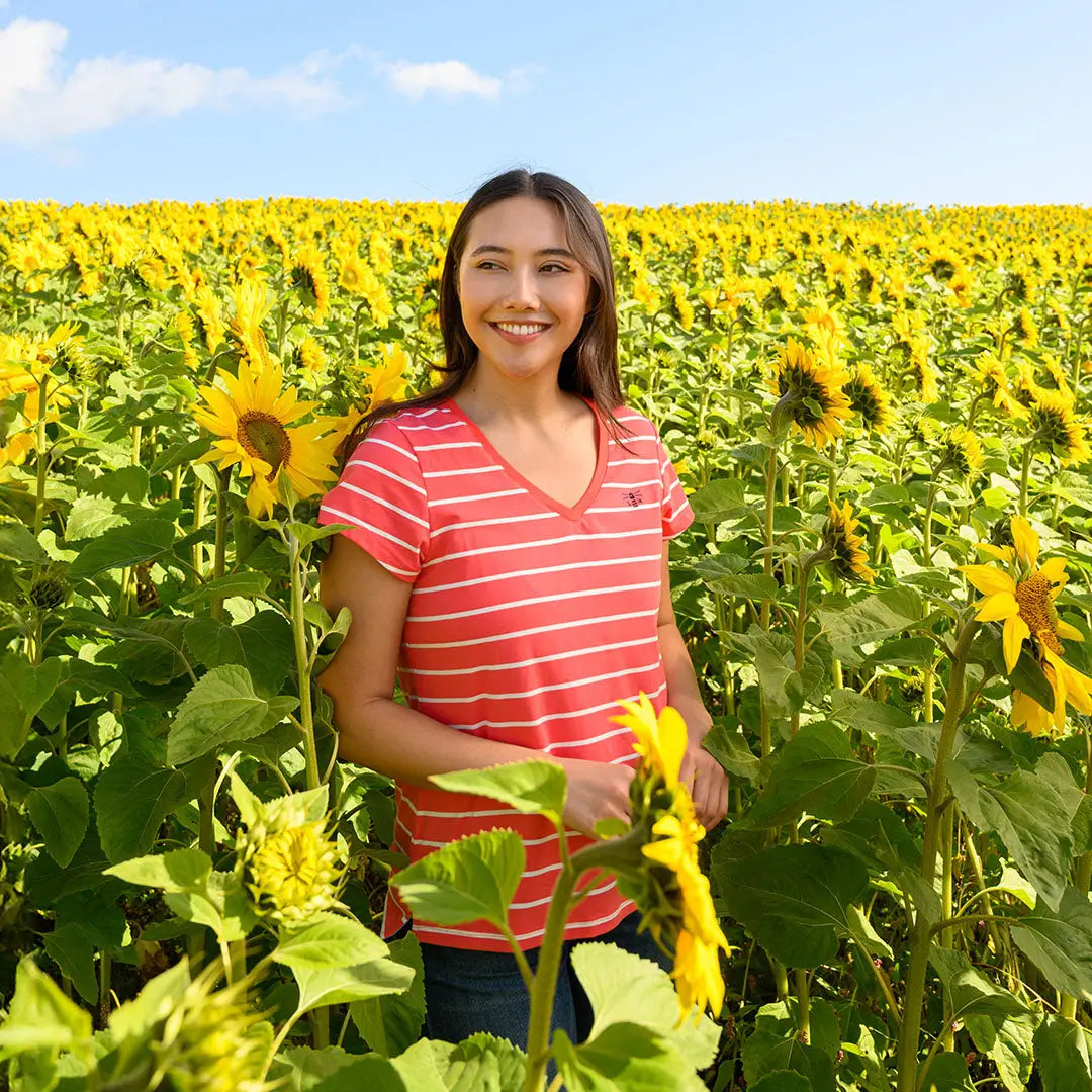 Smiling woman in sunflower field wearing Lighthouse Ladies Ariana Short Sleeve T-Shirt