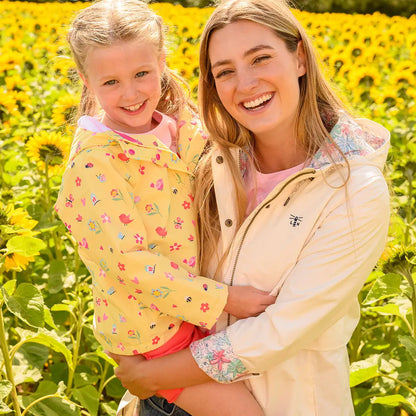 Smiling woman with a child in sunflower field wearing Lighthouse Ladies Pippa Coat