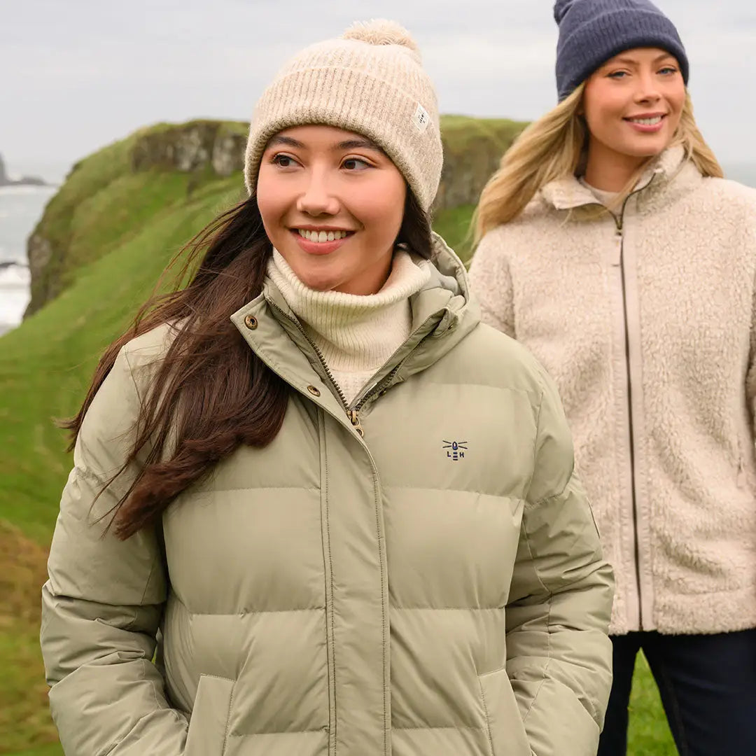 Woman in light green Lighthouse Savannah Coat with high collar and cream beanie