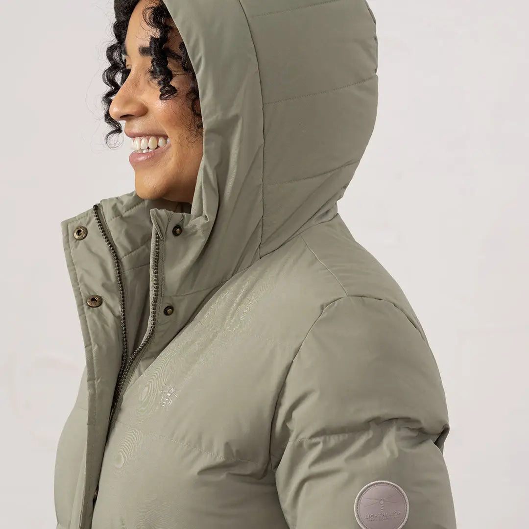 Woman in sage green Lighthouse Savannah Coat with hood, perfect for chilly days