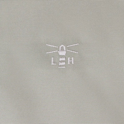 Light gray fabric with embroidered lighthouse logo on Lighthouse Scarlet Ladies Coat for outdoors