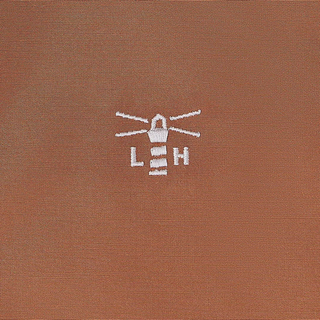 Brown fabric with white lighthouse logo on Lighthouse Scarlet Ladies Coat for country outdoor style