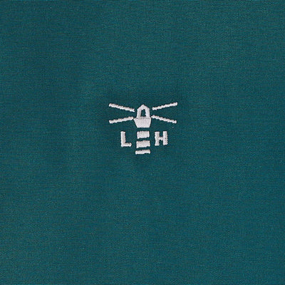Teal country clothing coat with white embroidered lighthouse logo for outdoors and hunting