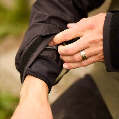 Hands clasped with a wedding ring, showcasing the Line 7 Storm Pro20 Jacket’s style