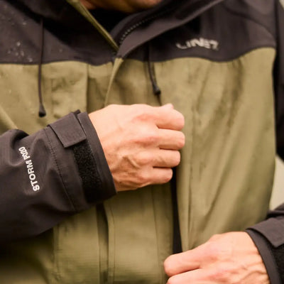 Hand gripping a Line 7 Storm Pro20 Jacket made of 000gm 24hr breathable nylon rip-stop fabric