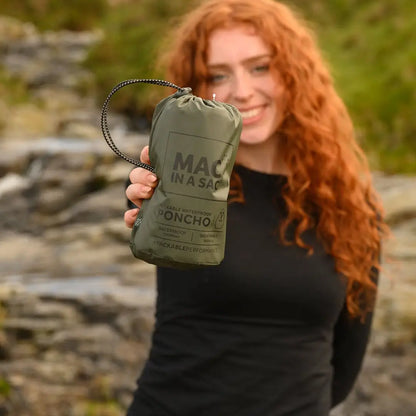 Olive green MAC IN A SAC Origin 2 Poncho held by a person with curly red hair