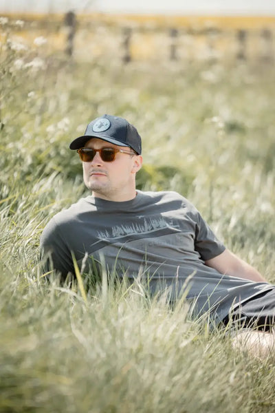 Man in sunglasses and cap lying on grass in New Forest 2-Tone Graphic T-Shirt forest clothing graphic