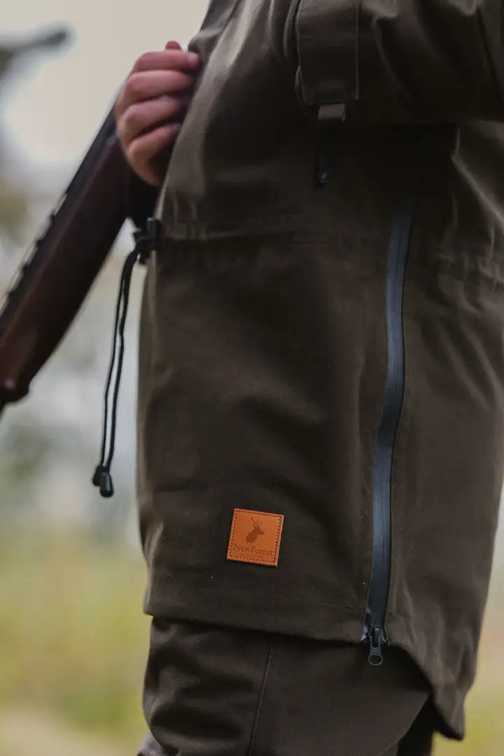 Person wearing olive green forest country sport smock with leather patch logo