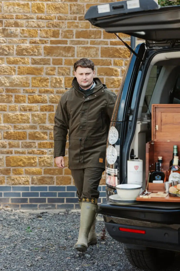 Man in forest country sport smock with dark olive waterproof jacket and light green wellingtons