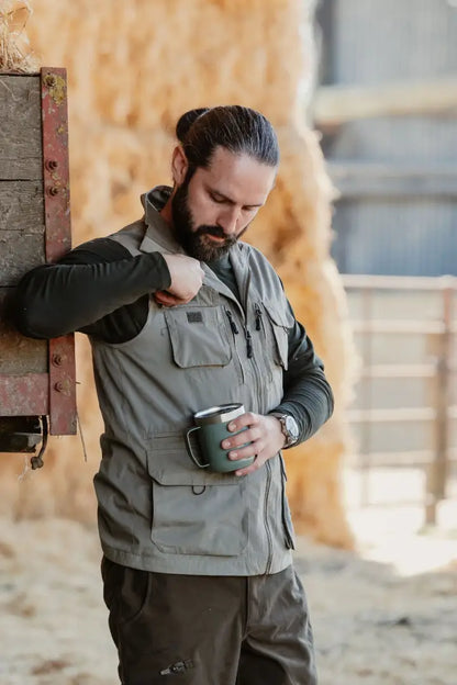 Man in vest holding mug wearing New Forest Explorer Gilet for outdoor adventures