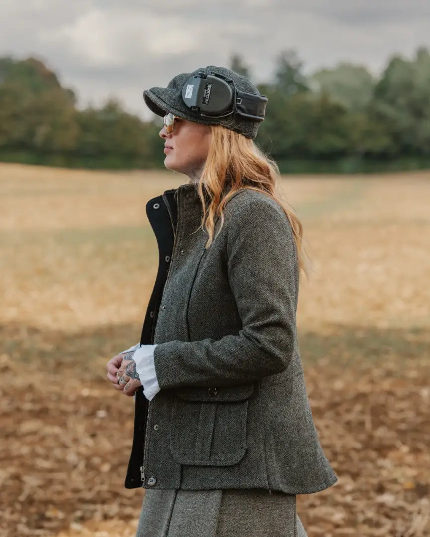 Woman wearing a Forest Florence Tweed jacket with cap and ear protection