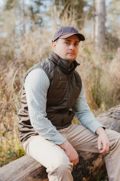 Man in vest and cap wearing New Forest Heated Gilet for cozy outdoor adventures