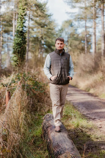 Man walking on a log wearing a New Forest Heated Gilet for outdoor comfort