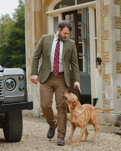 Man in Forest Heritage Tweed Blazer walking with a fox red Labrador outdoors
