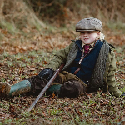 Young boy in hunting gear wearing a stylish Kids Tweed Shooting Jacket