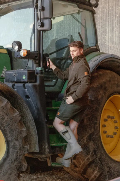 Man climbing into a Forest Knightwood zip fleece tractor embodying total comfort