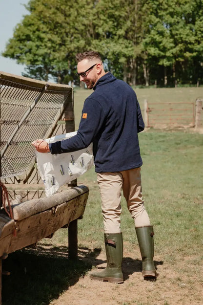 Man feeding livestock in New Forest Knightwood Quarter Zip Fleece, comfy quarter zip fleece
