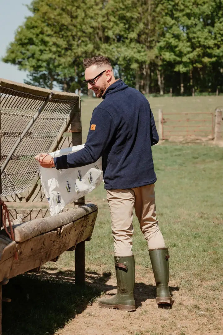 Man feeding livestock in New Forest Knightwood Quarter Zip Fleece, comfy quarter zip fleece