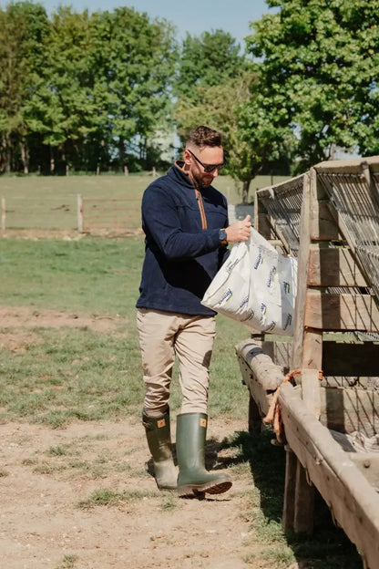 Man feeding livestock in New Forest Knightwood Quarter Zip Fleece, perfect quarter zip fleece wear