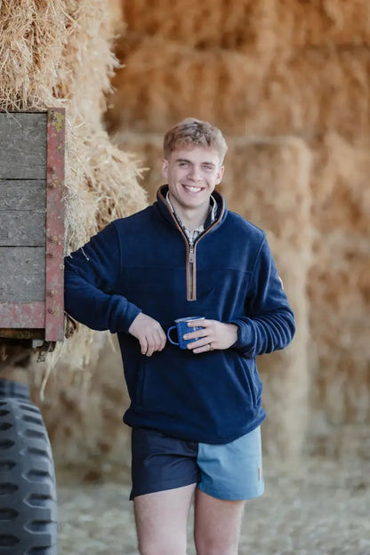Smiling man in Navy Knightwood Quarter Zip Fleece and color-blocked shorts