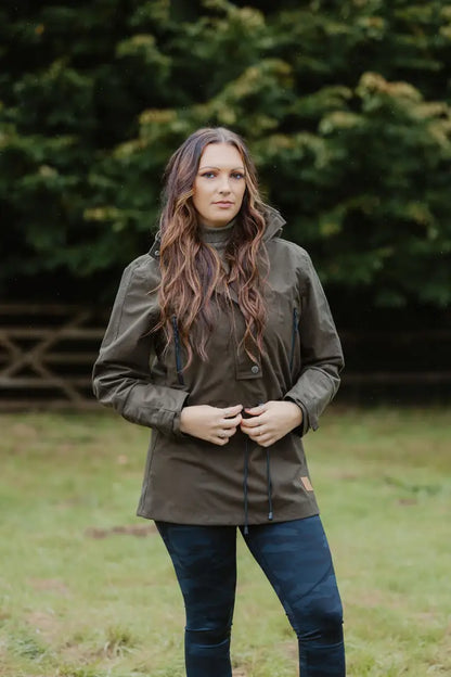 Woman in dark green country sport smock and blue jeans outdoors