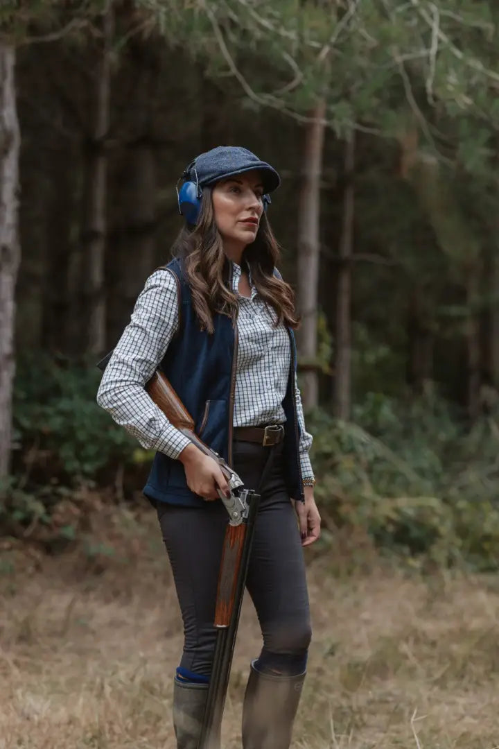 Woman in country attire holding a shotgun wearing New Forest Ladies Fleece Gilet