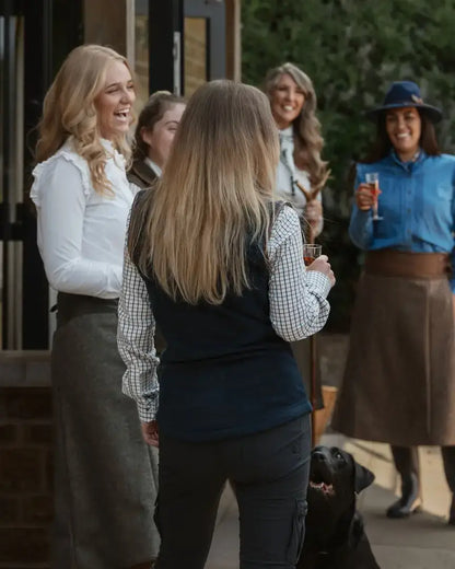 Forest ladies fleece gilet in action with women outdoors, a black dog, and drinks