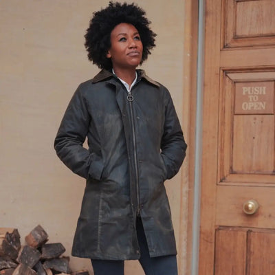 Woman with curly hair in a gray leather wax jacket, perfect for country clothing and hunting