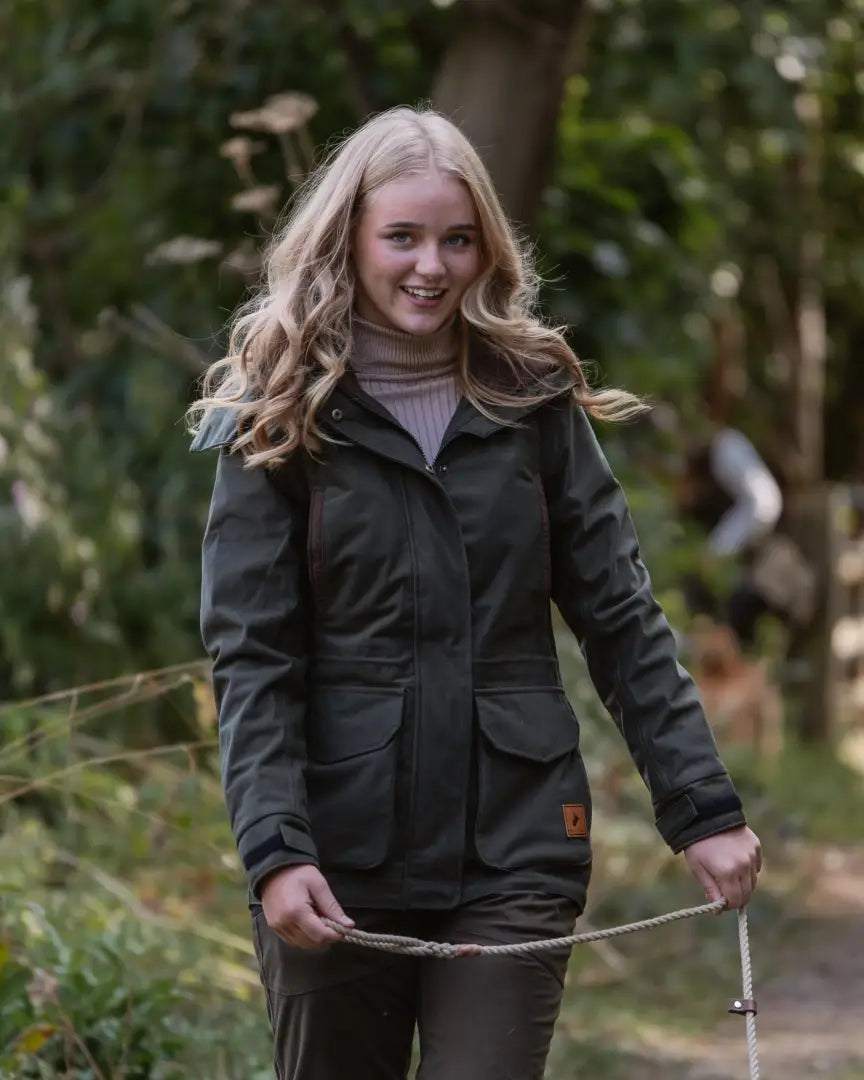 Young woman in forest ladies marsh jacket smiling and holding a rope outdoor style
