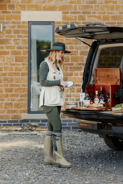 Woman in New Forest Ladies Outdoor Stretch Trousers enjoying a tailgate picnic with drinks and snacks