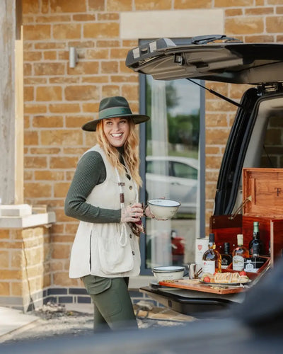 Smiling woman in New Forest Ladies Outdoor Stretch Trousers with wide-brimmed hat and vest