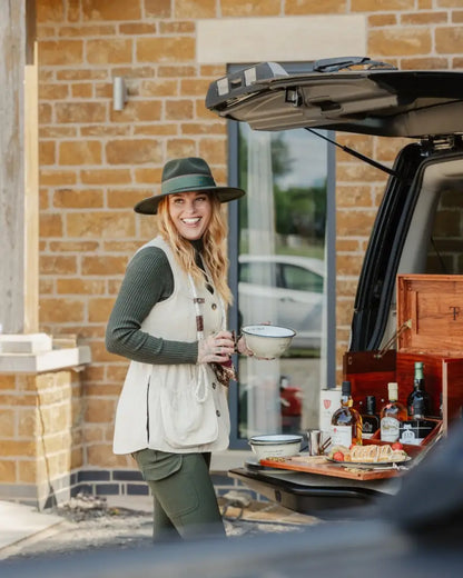 Smiling woman in New Forest Ladies Outdoor Stretch Trousers with wide-brimmed hat and vest